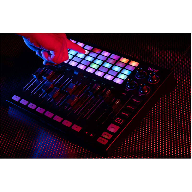 Hand pressing the lit 8 x 5 button matrix on the WING in a dark room - Hollywood DJ